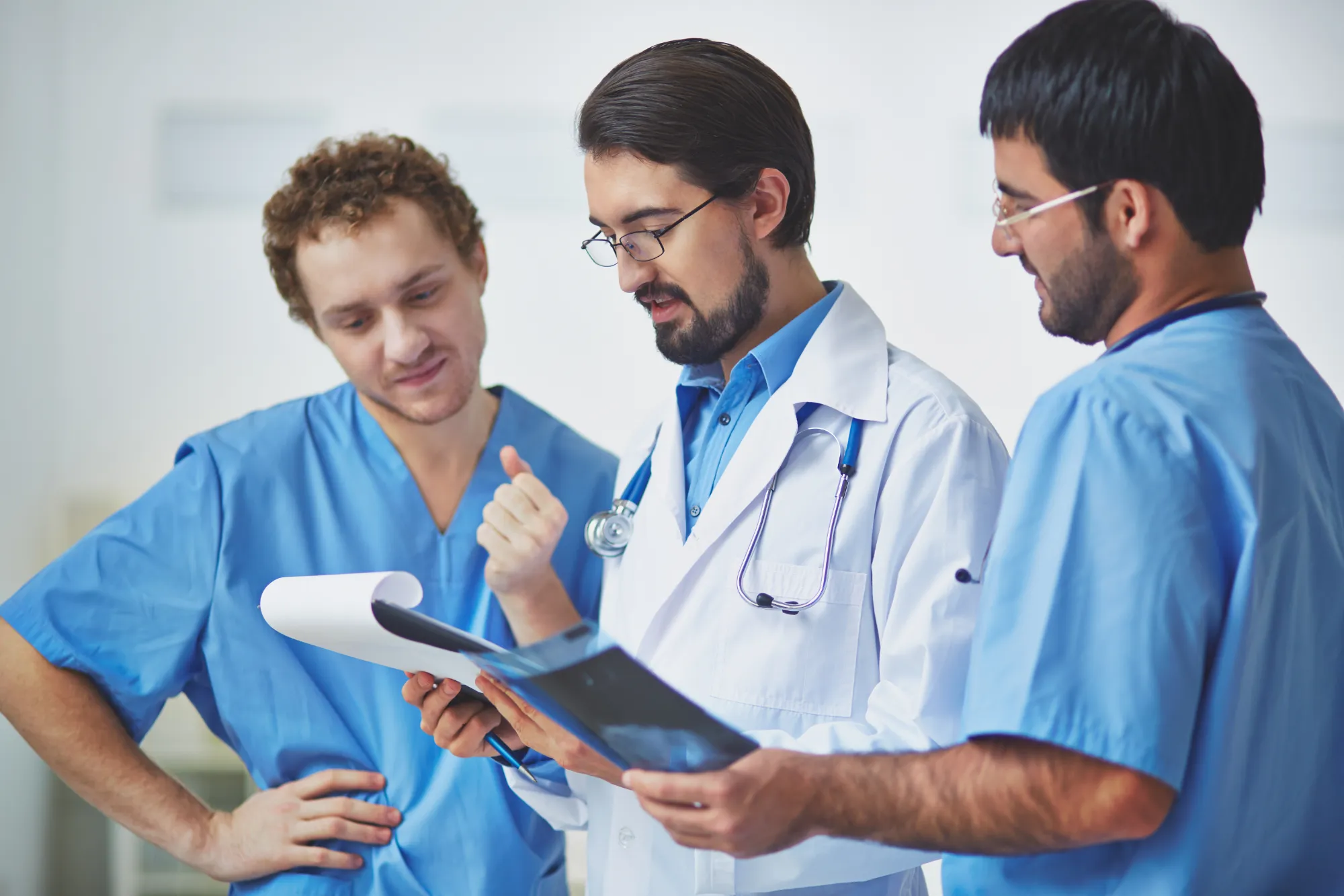 A doctor and two nurses discussing a chart together