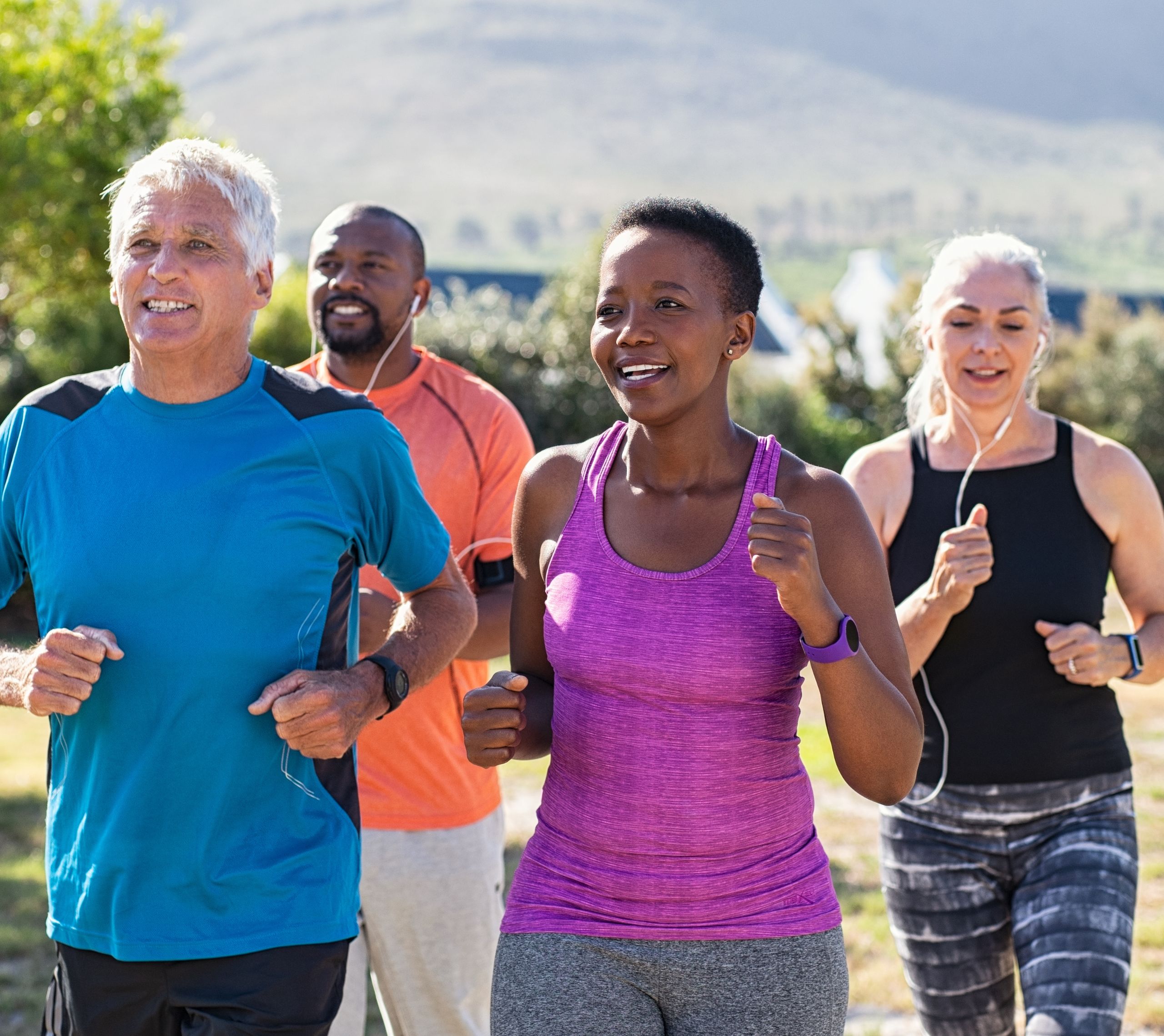 A group of middle-aged friends dressed in fitness apparel and jogging outside